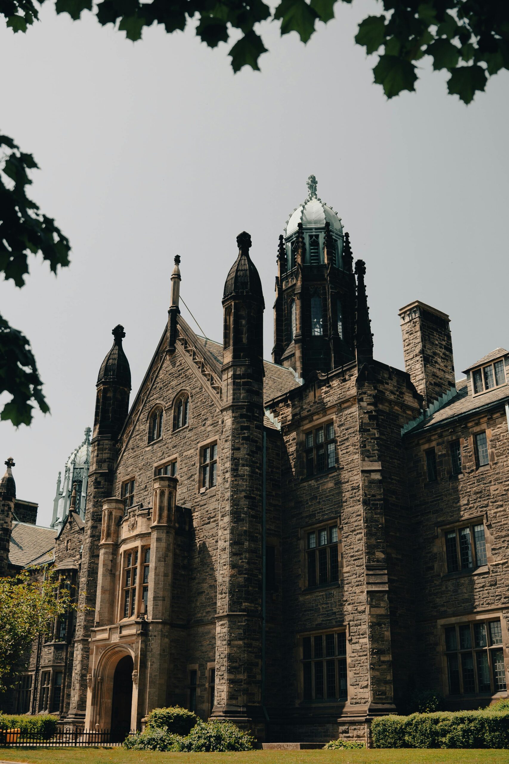 Historic Gothic Revival building surrounded by trees at Trinity College in Toronto.